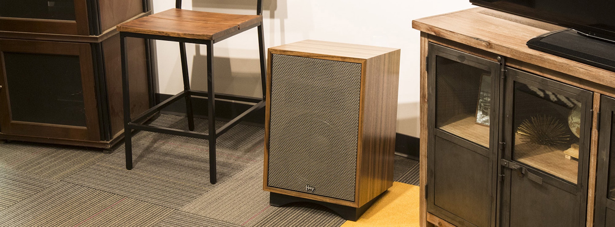 Klipsch Heresy next to a chair and cabinet